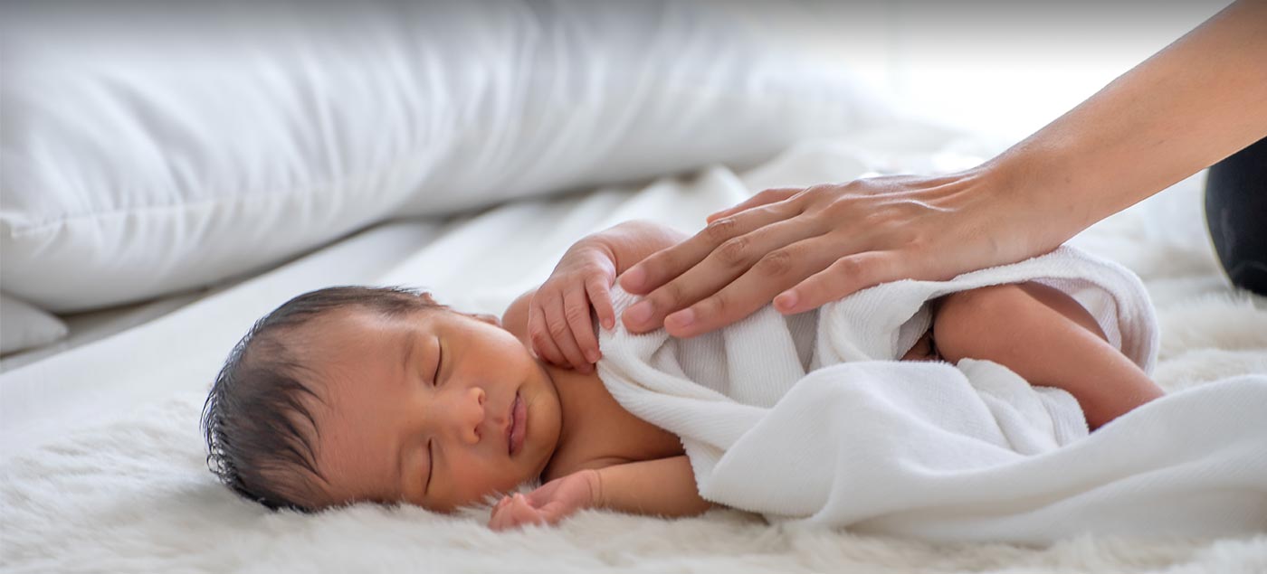 Un bébé enveloppé dans une couverture sur un lit