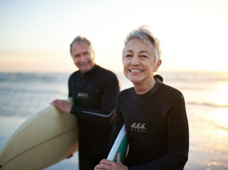 Couple en train de faire du surf sur une plage