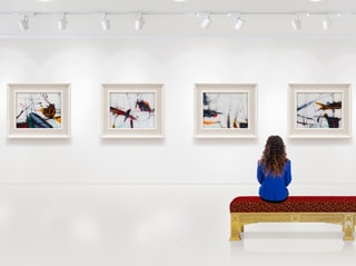 Une femme regardant des tableaux dans une galerie d’art