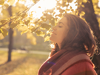 Jeune femme sereine prenant la lumière du soleil