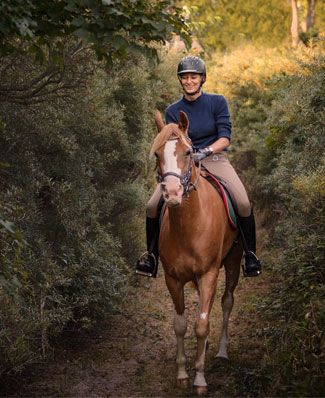 Equithérapie dans le cadre de la sclérose en plaques : une jeune femme à cheval.
