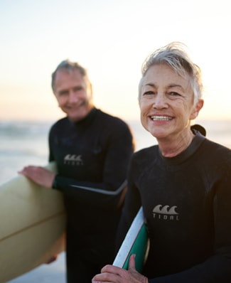 Couple en train de faire du surf sur une plage